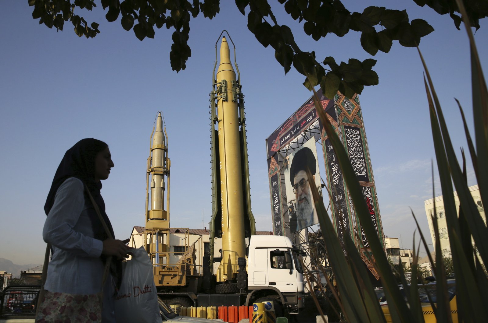 FILE - A Ghadr-H missile, center, a solid-fuel surface-to-surface Sejjil missile and a portrait of the Supreme Leader Ayatollah Ali Khamenei are on display for the annual Defense Week, marking the 37th anniversary of the 1980s Iran-Iraq war, at Baharestan Sq. in Tehran, Iran, Sept. 24, 2017. (AP File Photo)