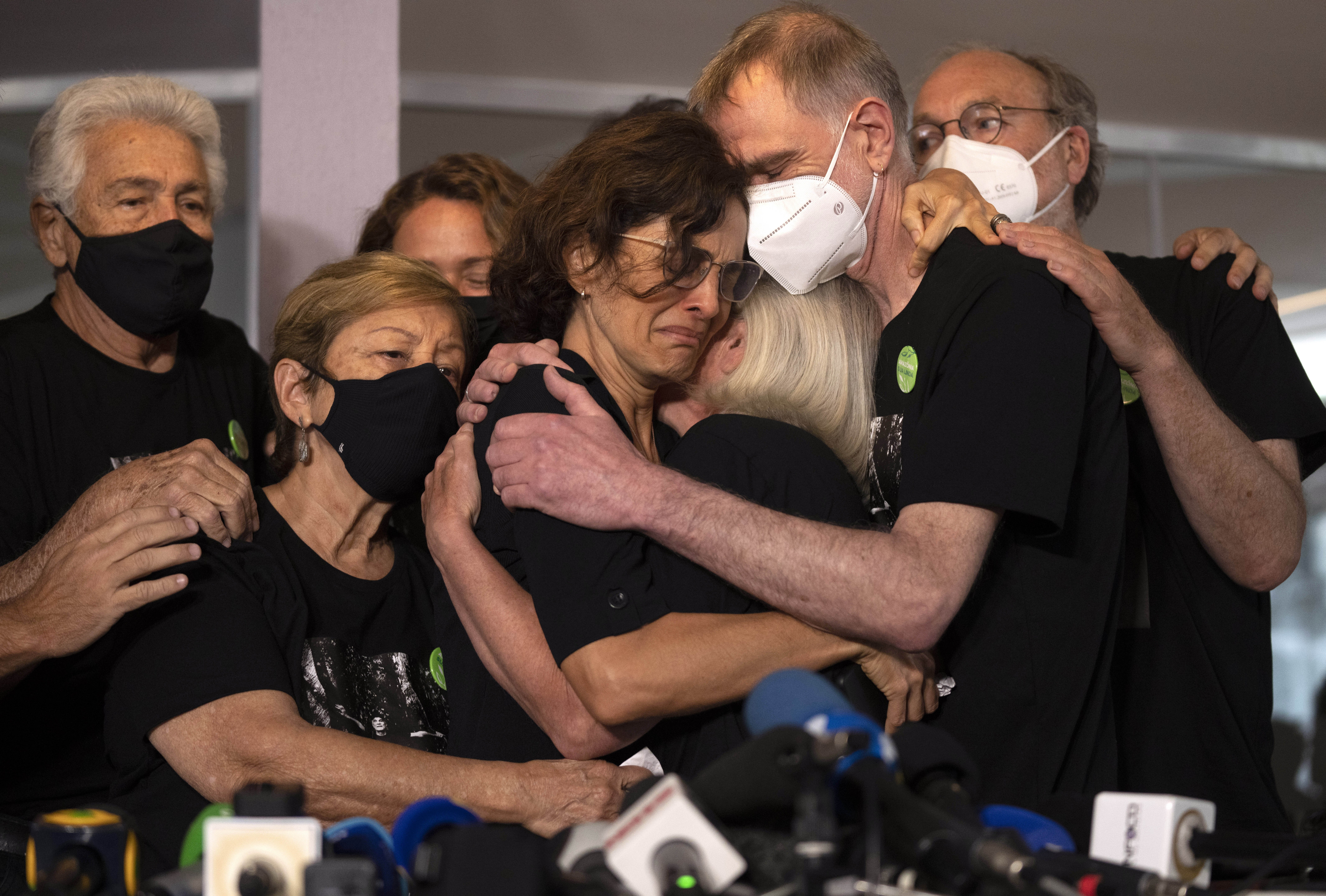 Relatives mourn as Alessandra Sampaio (C) embraces her sister-in-law Sian Phillips after speaking to the media during the funeral of her husband British journalist Dom Phillips at the Parque da Colina cemetery in Niteroi, Brazil, June 26, 2022. (AP Photo/Silvia Izquierdo)