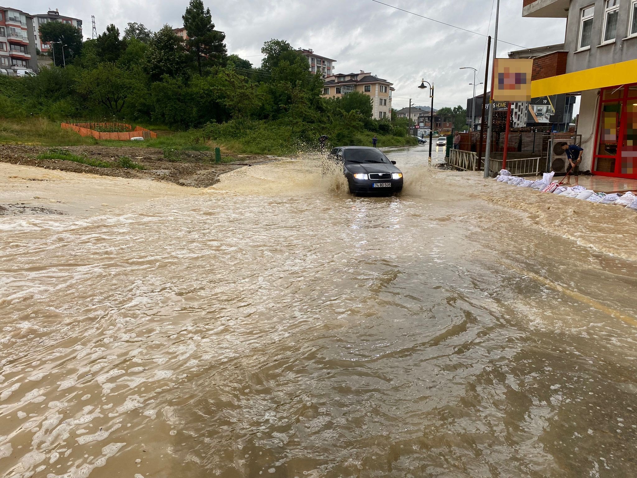 A car drives through a flooded street in Bartın, northern Turkey, June 27, 2022. (IHA PHOTO)