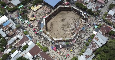 In this image taken from video, spectators gather around the wooden stands that collapsed during a bullfight in El Espinal, Tolima state, Colombia, June 26, 2022. (AP Photo)