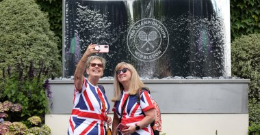 Spectators pose for a selfie before the start of play at the Wimbledon, London, England, June 27, 2022. (Reuters Photo)