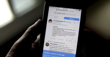 A man reads tweets by Indian celebrities, one of the many backing the Indian government, on his mobile in New Delhi, India, Feb. 4, 2021. (AP Photo)