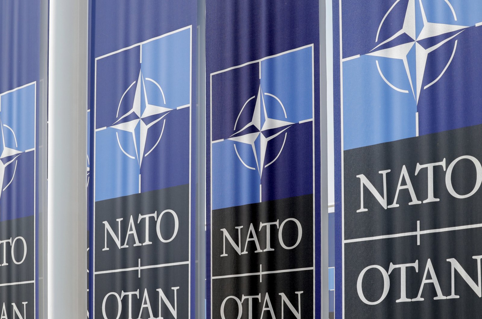 Cloth banners flap in the wind outside NATO headquarters in Brussels, Wednesday, June 15, 2022. (AP Photo)