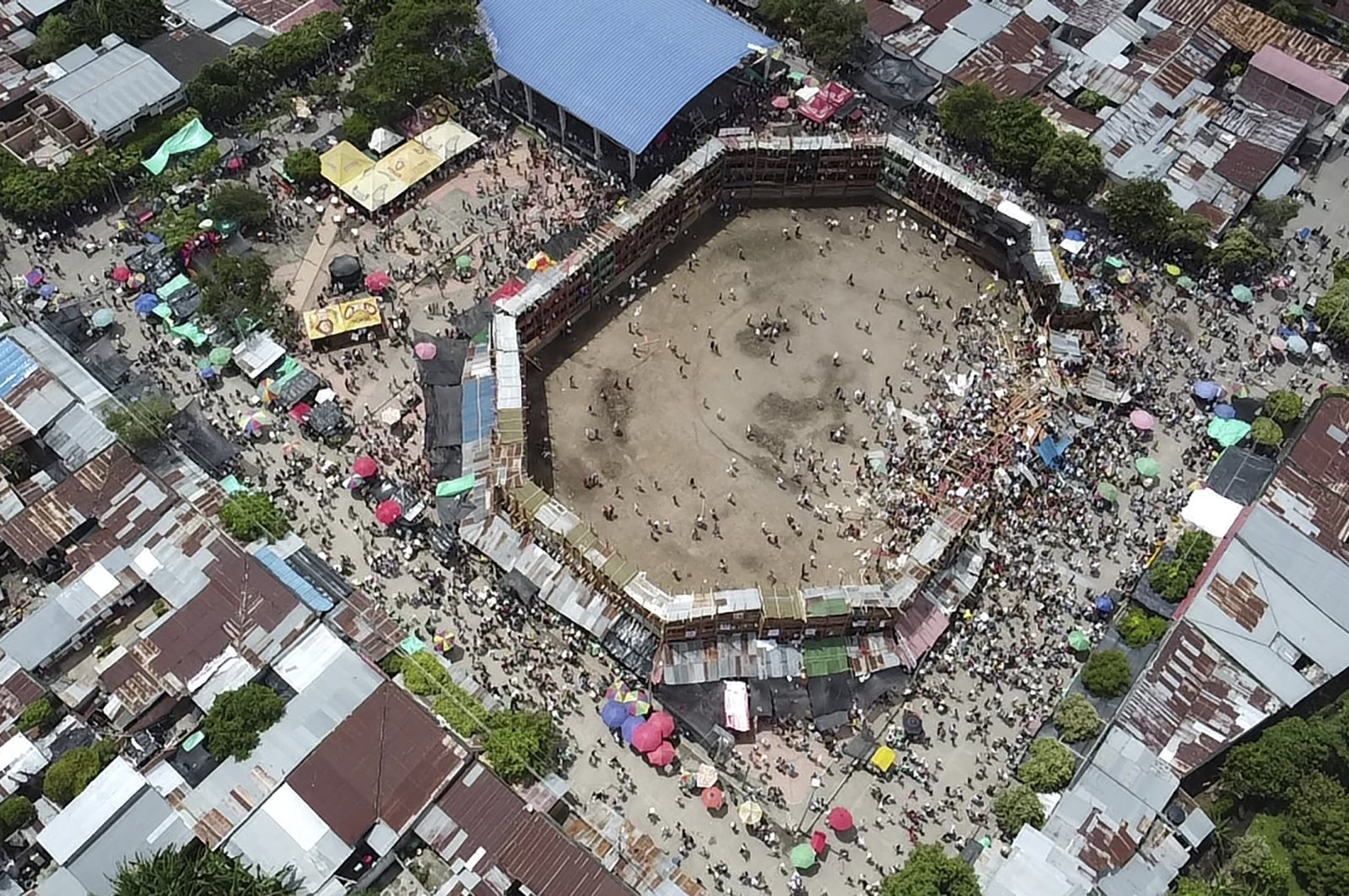 In this image taken from video, spectators gather around the wooden stands that collapsed during a bullfight in El Espinal, Tolima state, Colombia, June 26, 2022. (AP Photo)