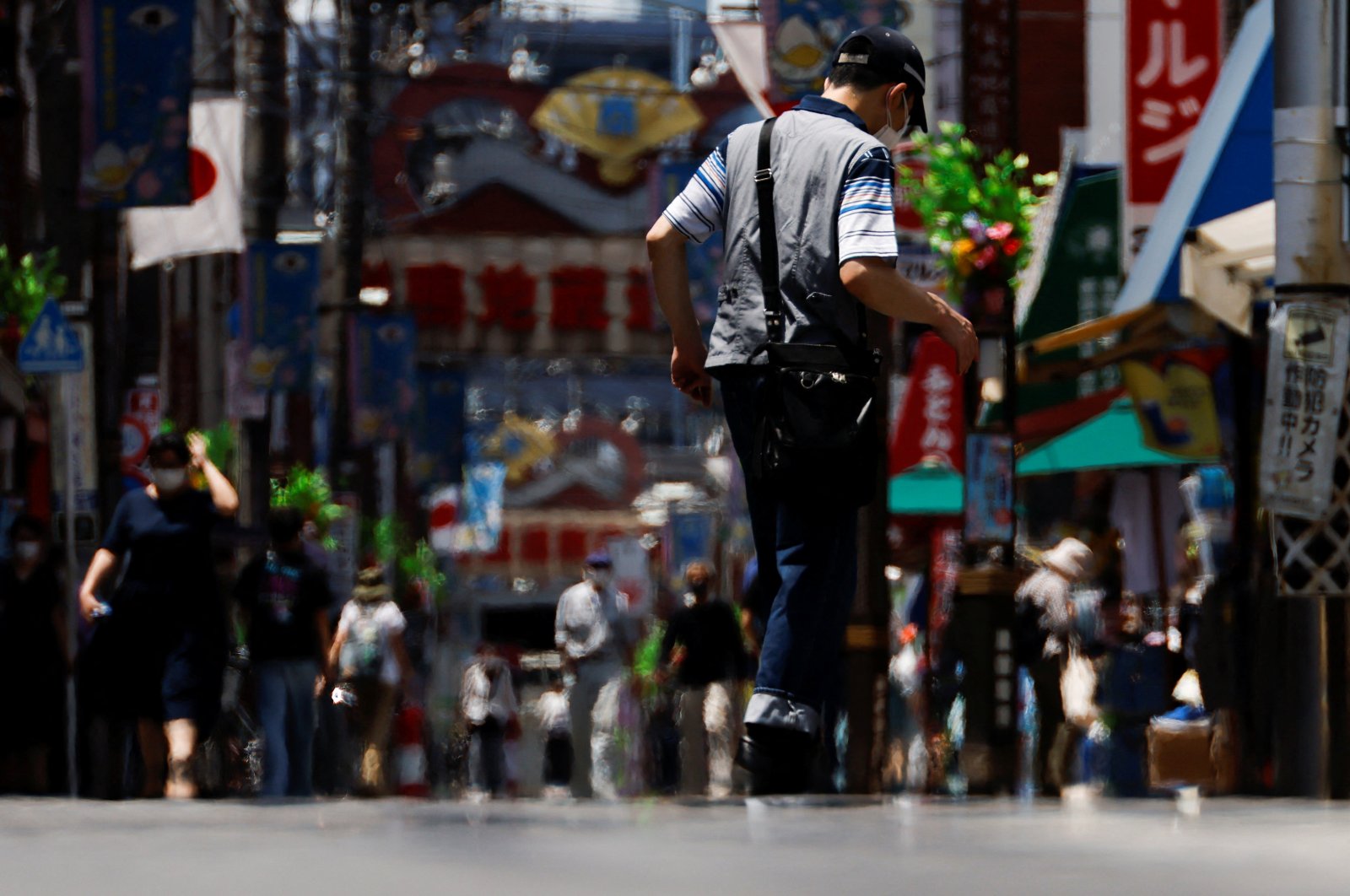 Passersby are seen through a heat haze during hot weather at Sugamo district in Tokyo, Japan, June 27, 2022. (Reuters Photo)  