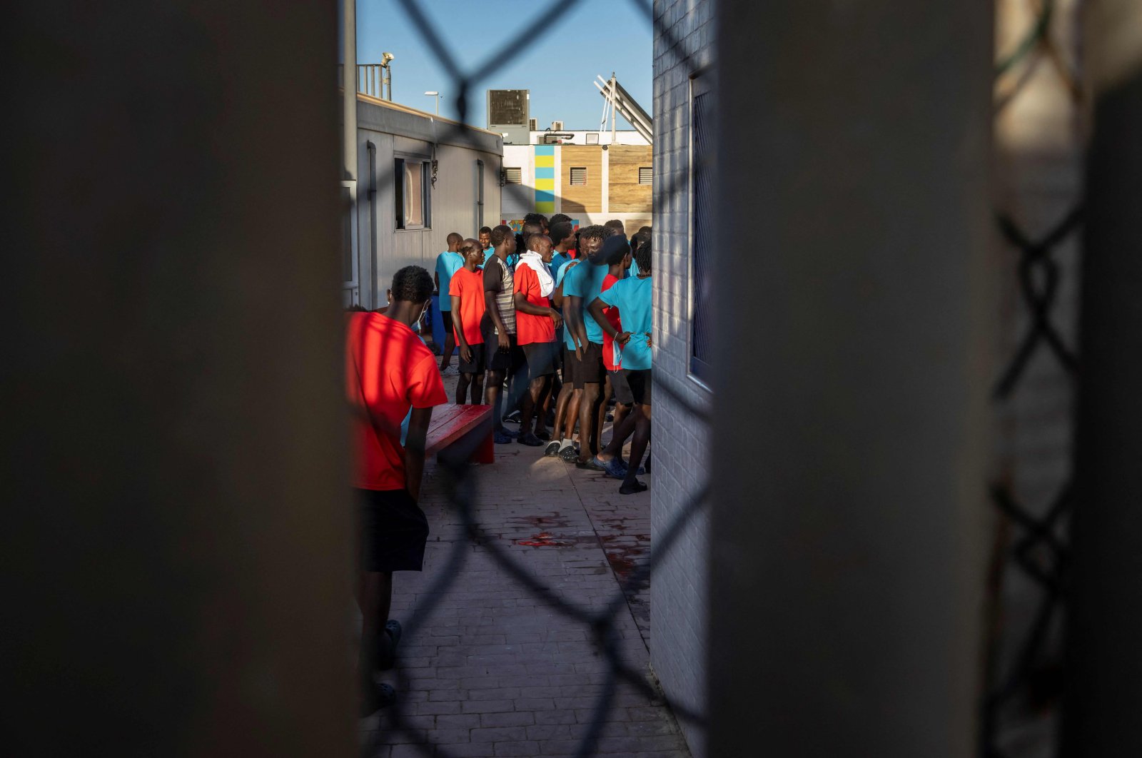 Migrants line up in a temporary center for migrants and asylum-seekers in Melilla, a day after at least 23 African migrants were killed in a bid to enter the northern Morocco Spanish enclave, June 25, 2022. (AFP Photo)