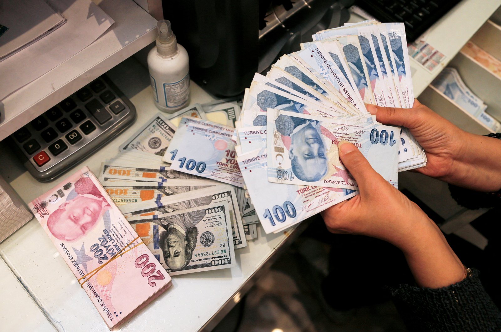 A money changer holds Turkish lira banknotes at a currency exchange office in Ankara, Turkey, Oct. 12, 2021. (Reuters File Photo)