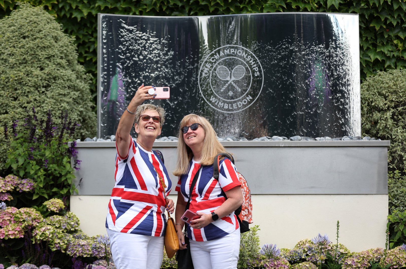 Spectators pose for a selfie before the start of play at the Wimbledon, London, England, June 27, 2022. (Reuters Photo)