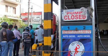 People stand outside a closed Ceylon Petroleum Corporation fuel station that ran out of gasoline in Colombo, Sri Lanka, June 27, 2022. (AFP Photo)