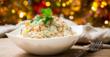 A bowl of russian salad is seen on a wooden table (Shutterstock)
