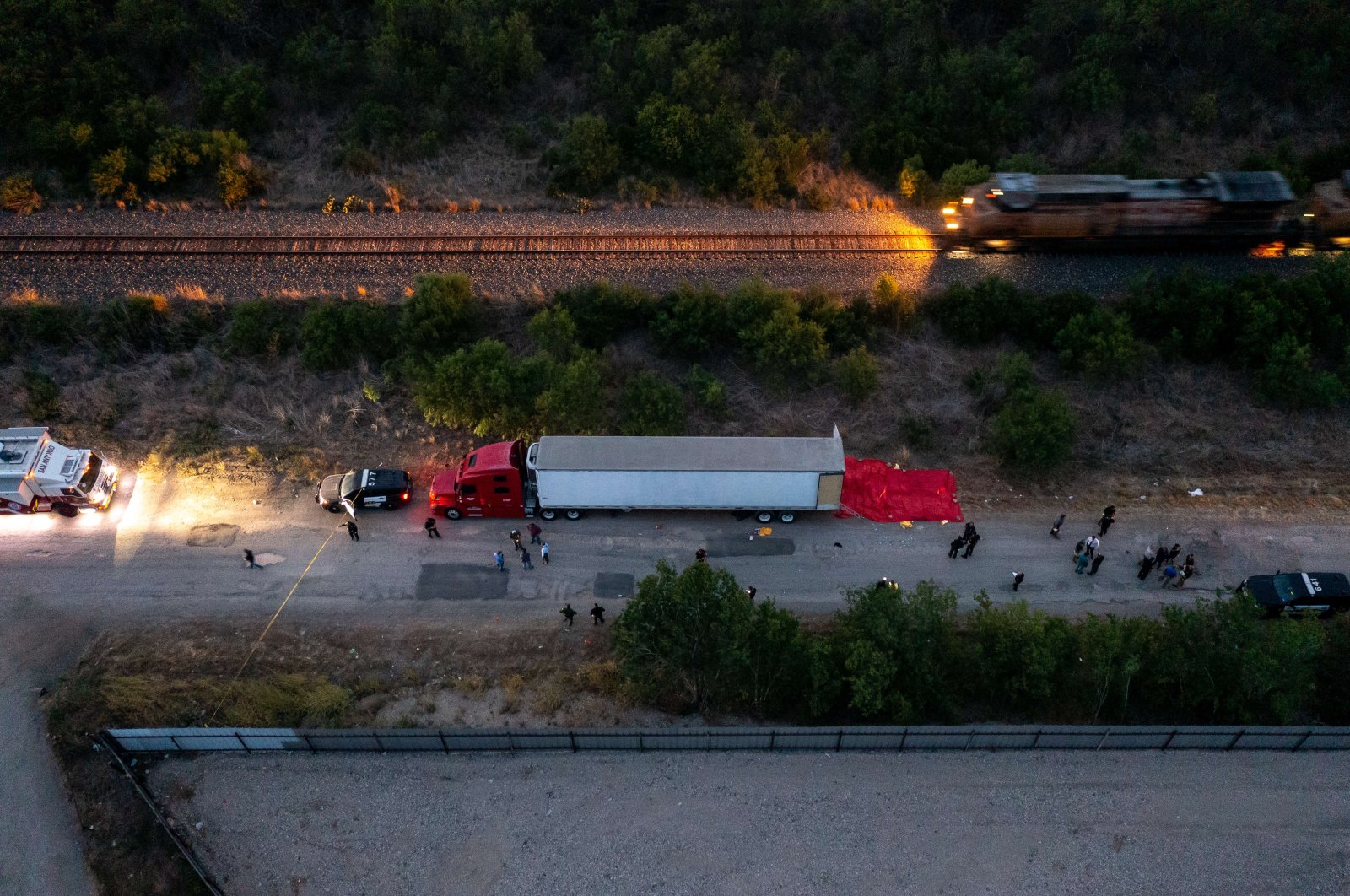 In this aerial view, members of law enforcement investigate a tractor trailer in San Antonio, Texas, U.S., June 27, 2022. (AFP Photo)