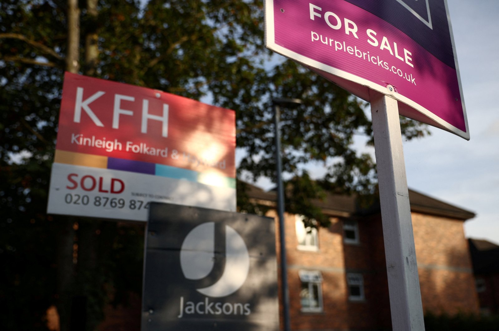 Real estate agent sales and letting signs are seen attached to railings outside an apartment building in south London, Britain, Sept. 23, 2021. (Reuters Photo)