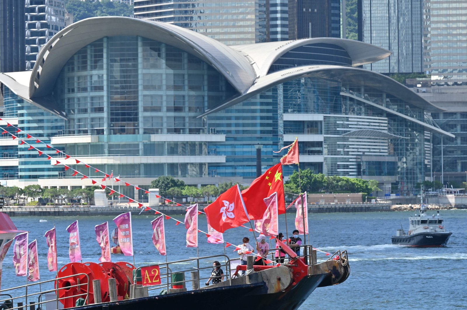 A fishing boat with banners and flags to mark the 25th anniversary of the handover of Hong Kong from Britain to China sails through Victoria harbor, Hong Kong, June 28, 2022. (AFP Photo)