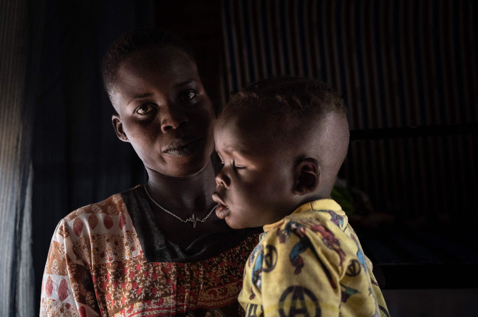 South Sudanese asylum seeker Nyalada Gatkouth Jany (L) who tried to cross the Mediterranean Sea four times and imprisoned in Libya, sits with her 1-year-old child, Rwanda, June 10, 2022. (AFP Photo)