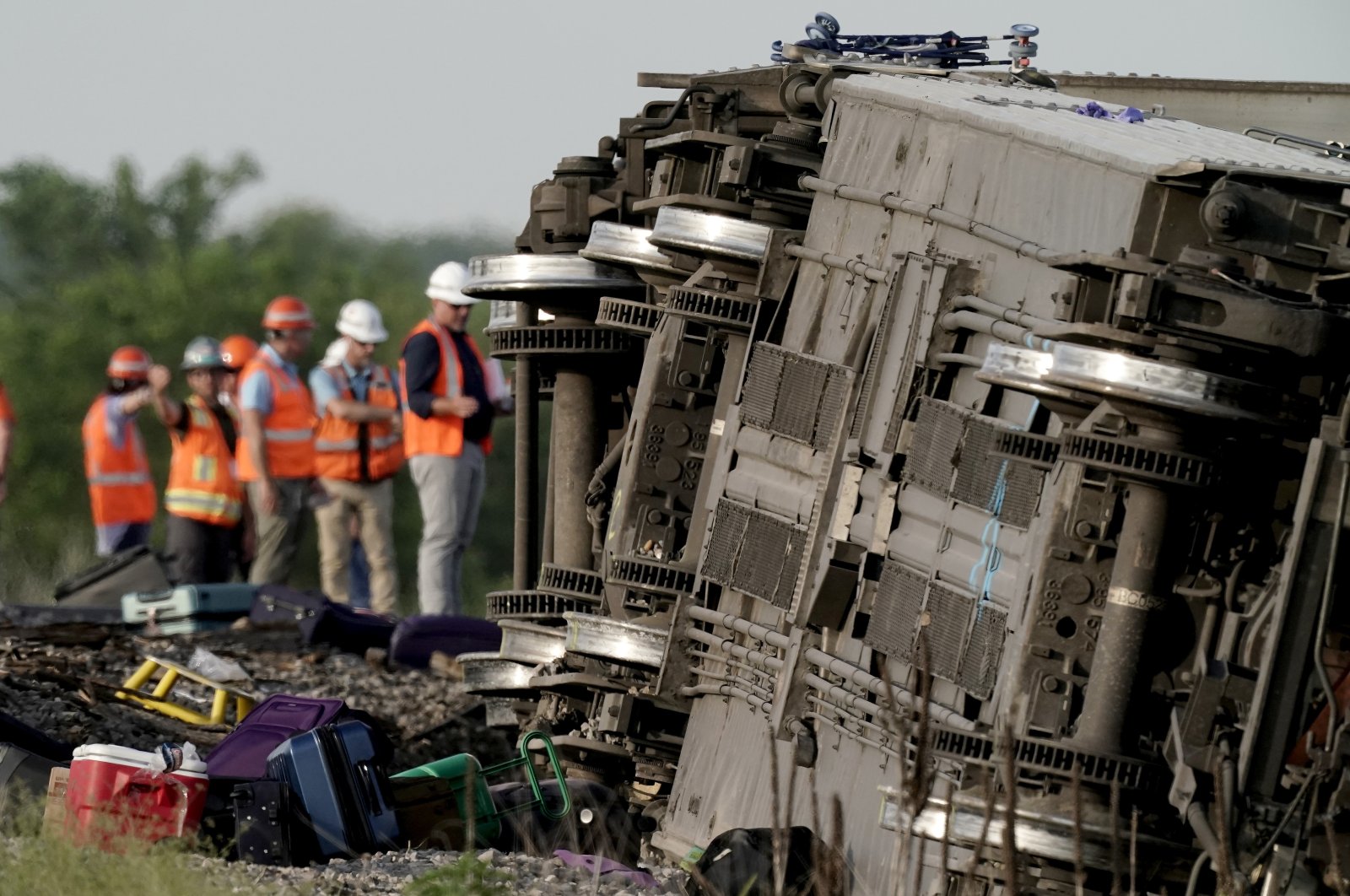Workers inspect the scene of an Amtrak train which derailed after striking a dump truck, near Mendon, Missouri, U.S., June 27, 2022. (AP Photo)