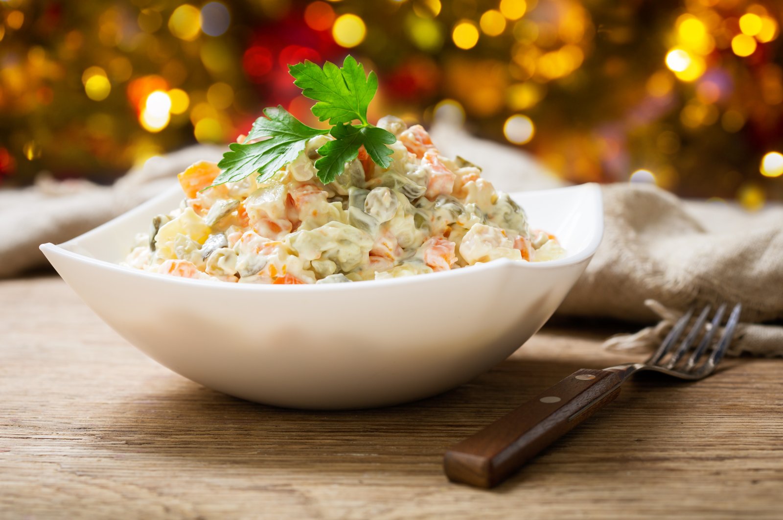 A bowl of russian salad is seen on a wooden table (Shutterstock)