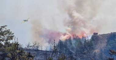 A firefighting aircraft drops water on a wildfire near Marmaris, a town in Muğla province, Turkey, June 22, 2022. (Reuters Photo)
