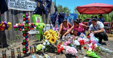 People place flowers and candles at a makeshift memorial where a tractor-trailer was discovered with migrants inside, outside San Antonio, Texas, U.S., June 29, 2022. (AFP Photo)