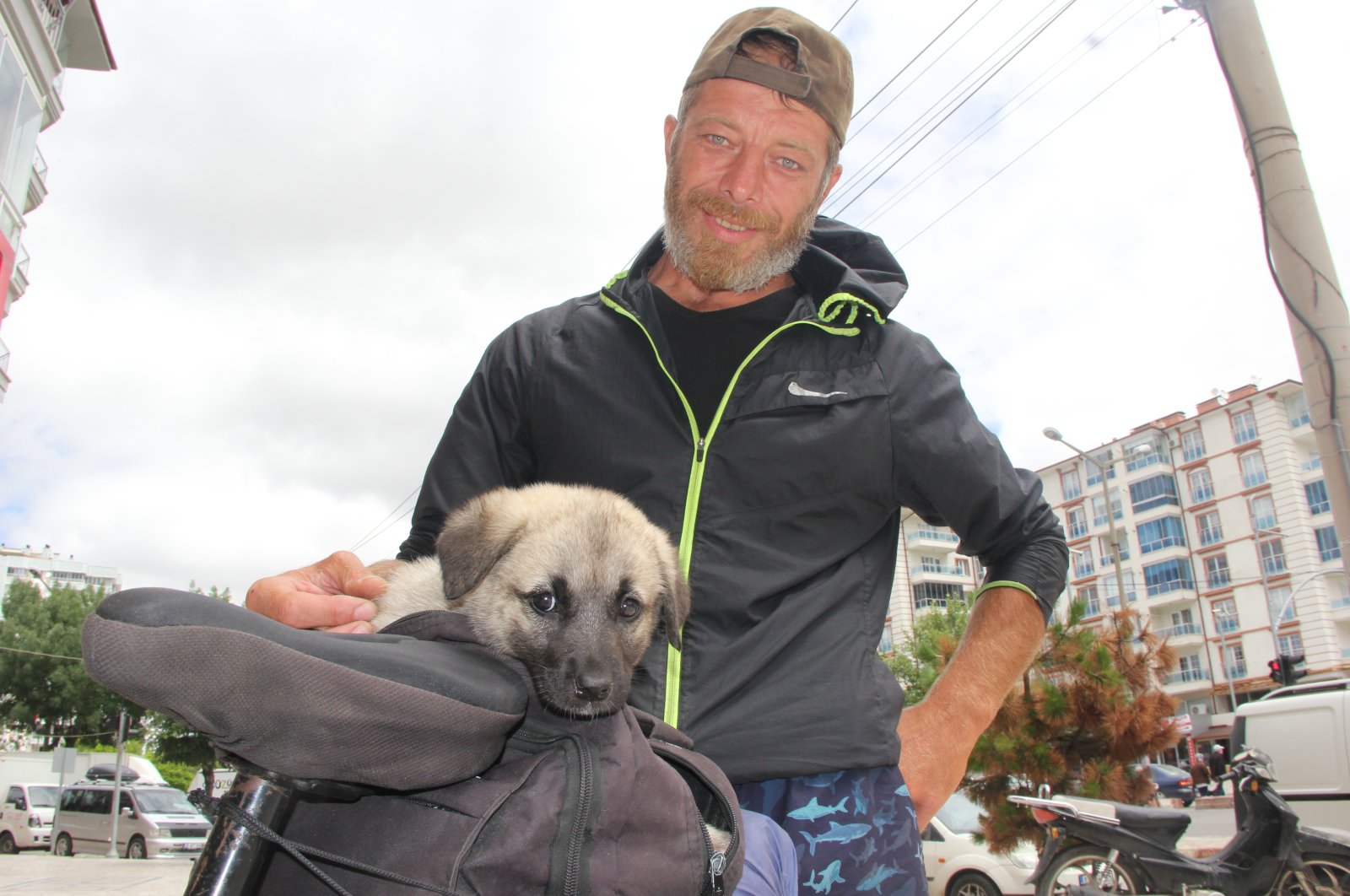 The cyclist Onur Yorulmaz, 40, who set out from Istanbul and traveled to 29 cities so far, is touring Turkey with a 2-month-old puppy that he adopted after its mother died, Afyonkarahisar, Turkey, June 29, 2022. (AA Photo)