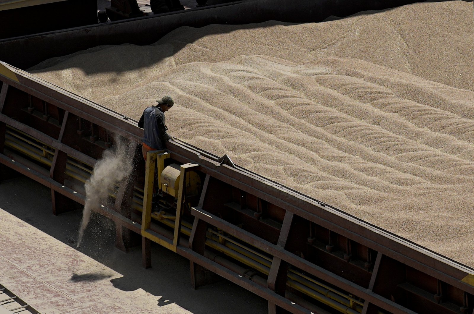 An employee of the Romanian grain handling operator Comvex oversees the unloading of Ukrainian grain from a barge in the Black Sea port of Constanta, Romania, June 21, 2022. (AP Photo)