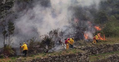 Firefighters are working to put out a fire in the bush surrounding the ruins of Llamakancha, a sector in the archaeological site of Machu Picchu, Peru, June 28, 2022. (Machu Picchu Municipality via AFP)