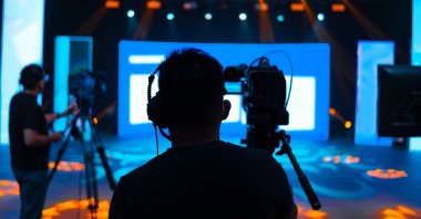 A camera operator covering an event on live studio news. (Shutterstock)