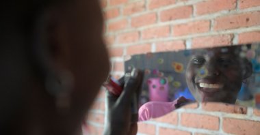 A South Sudanese asylum-seeker combs her hair in a mirror at her temporary house at Gashora Emergency Transit Centre in Gashora, Rwanda, June 25, 2022. (AFP Photo)
