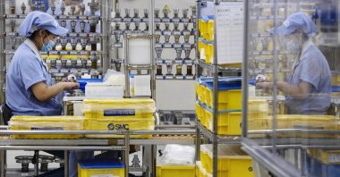 A worker assembles products at a factory in Beijing, China, May 13, 2020. (AP Photo)
