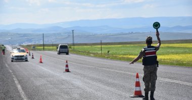 A gendarmerie officer stops vehicles to warn them about the speed limit, in Kars, eastern Turkey, June 30, 2022. (AA PHOTO)