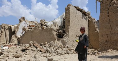 A child stands next to a collapsed building in Paktika, Afghanistan, June 29, 2022. (AA PHOTO)