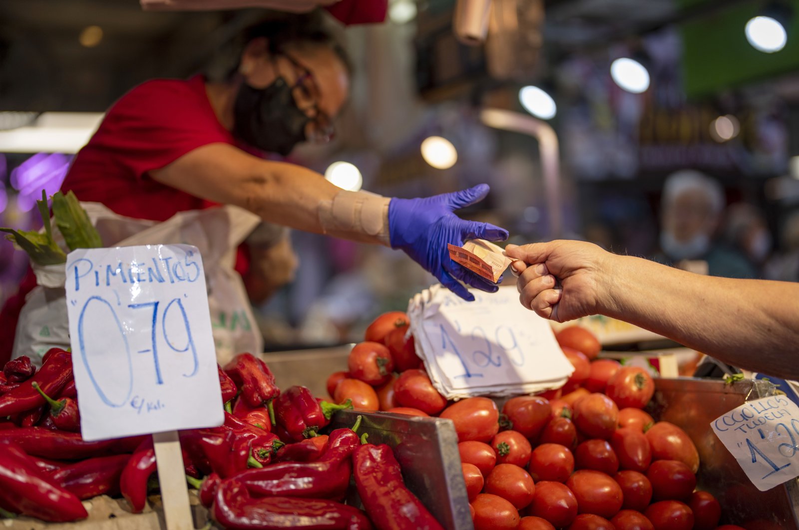 A customer pays for vegetables at the Maravillas market in Madrid, Spain, May 12, 2022. (AP Photo)