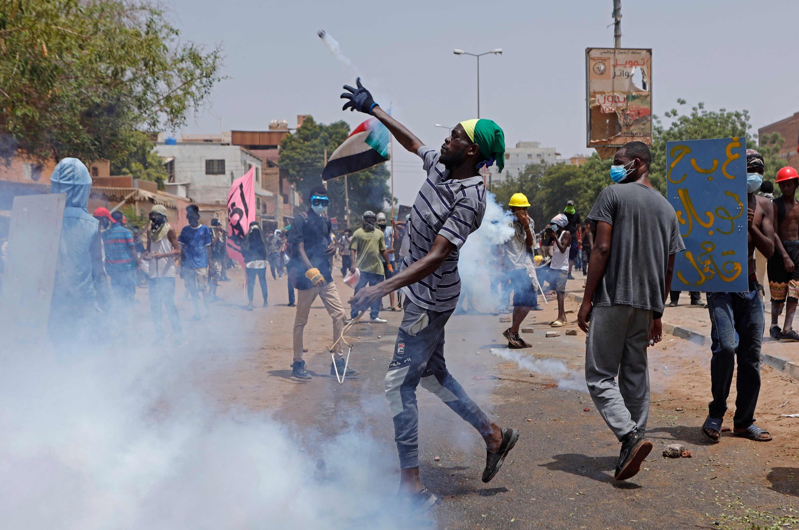 An anti-coup protester throws back a tear gas canister at security forces during clashes amid mass demonstrations against military rule, Khartoum, Sudan, June 30, 2022. (AFP Photo)