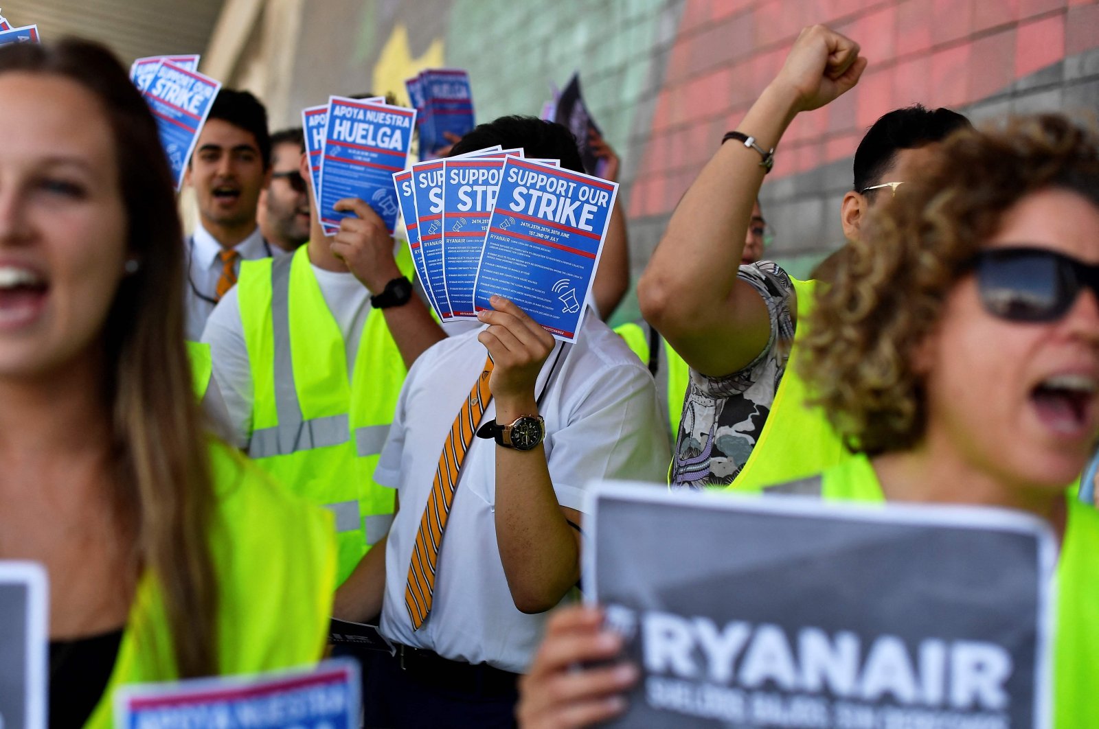 Ryanair employees hold flyers reading "Support our strike" as they protest at the Terminal 2 of El Prat airport in Barcelona, Spain, July 1, 2022. (AFP Photo)