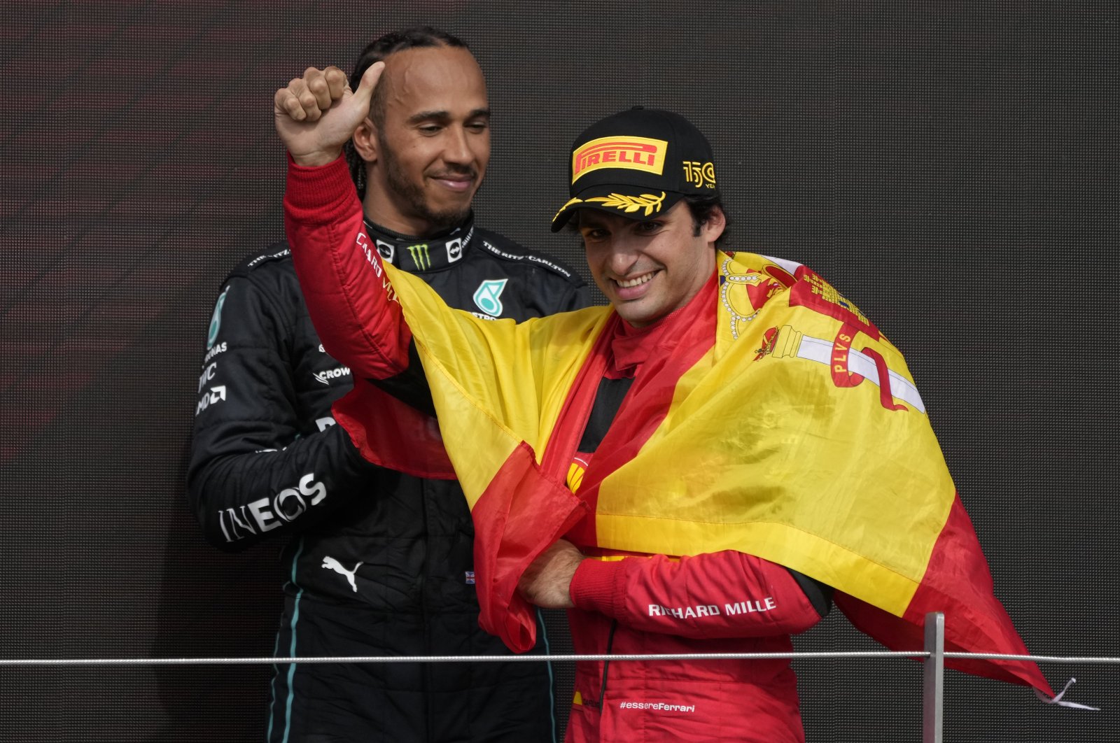 Ferrari&#039;s Carlos Sainz celebrates winning the British F1 GP as Mercedes&#039; Lewis Hamilton, rear, looks on, Silverstone, England, July 3, 2022. (AP Photo)