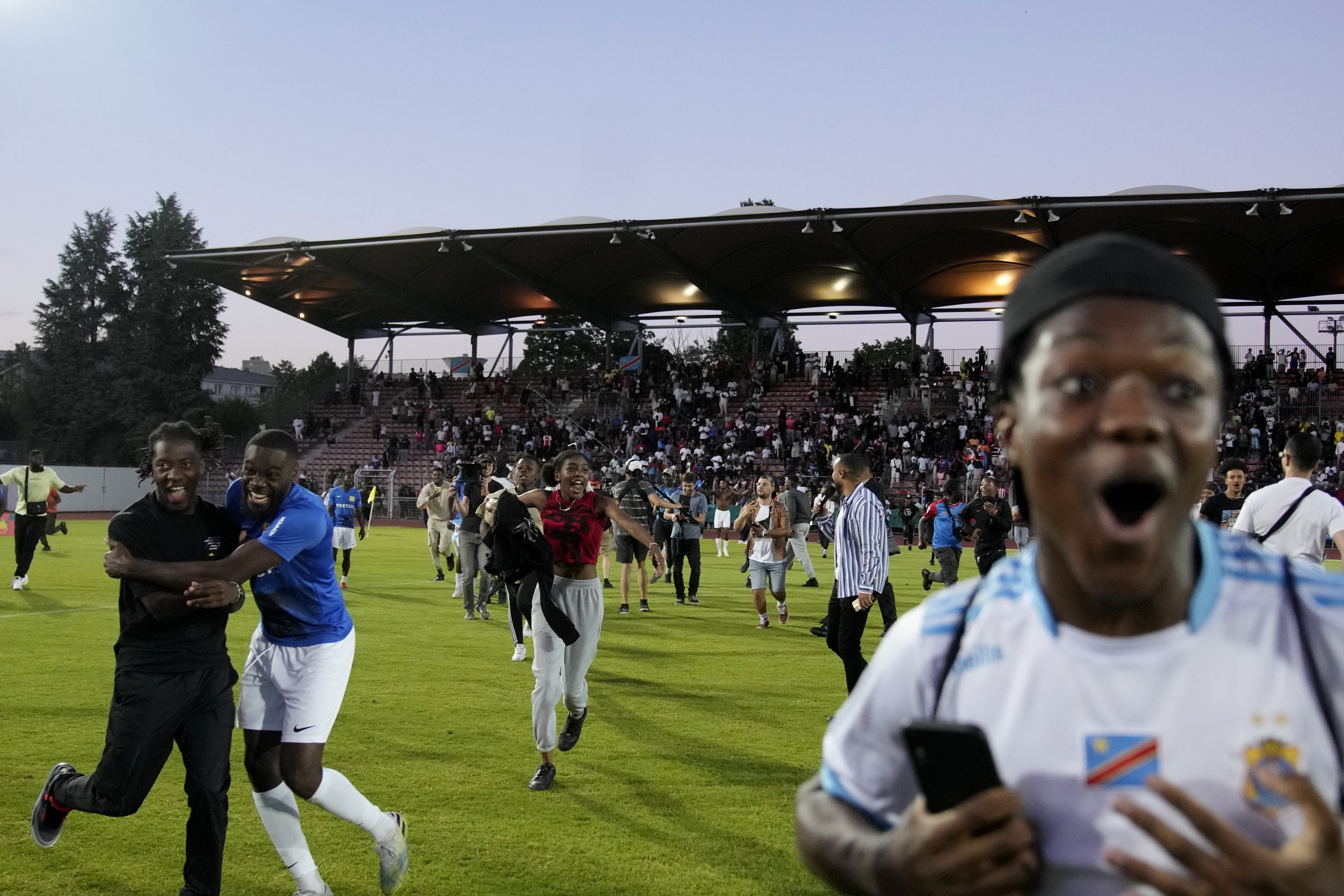 Penggemar Kongo memasuki lapangan setelah Kongo mengalahkan Mali selama pertandingan terakhir piala nasional lingkungan kelas pekerja antara tim yang mewakili pemain dengan warisan Mali melawan satu dengan akar Kongo, di Creteil, Prancis, 2 Juli 2022. (AP Photo)