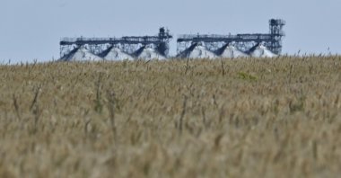 A photograph shows a grain elevator behind a wheat field in Ukraine&#039;s eastern region of Donbas, on July 1, 2022. (AFP Photo)