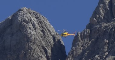 A rescue helicopter hovers over the Punta Rocca glacier near Canazei, in the Italian Alps in northern Italy,  a day after a huge chunk of the glacier broke loose, sending an avalanche of ice, snow and rocks onto hikers, July 4, 2022. (AP Photo)