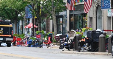 Empty chairs sit along the sidewalk after parade-goers fled Highland Park's Fourth of July parade after shots were fired, Chicago, Illinois, U.S., July 4, 2022. (Tyler Pasciak LaRiviere/Chicago Sun-Times via AP)