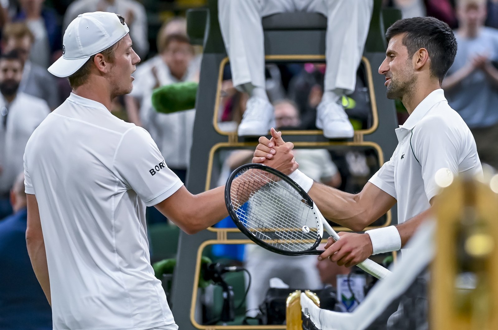 Novak Djokovic (R) greets Tim van Rijthoven (L) during their Wimbledon men&#039;s fourth-round match, Wimbledon, England, July 3, 2022. (EPA Photo)
