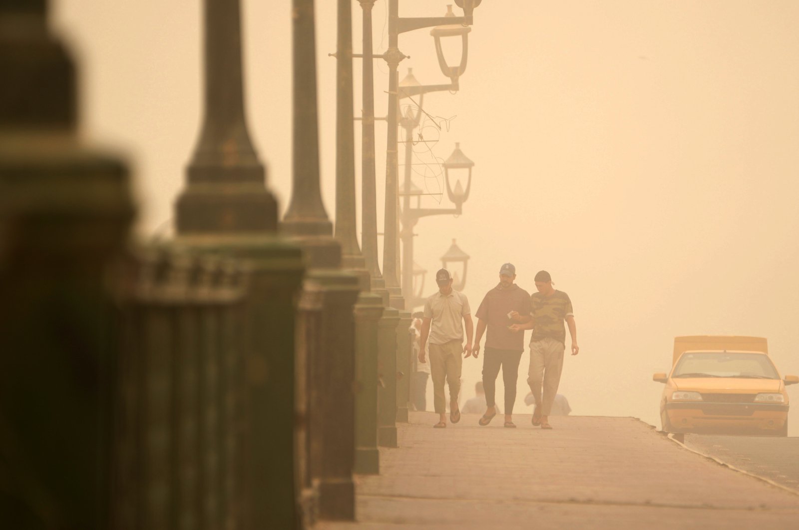 People walk on a bridge during a sandstorm in Baghdad, Iraq, July 3, 2022. (AP Photo)
