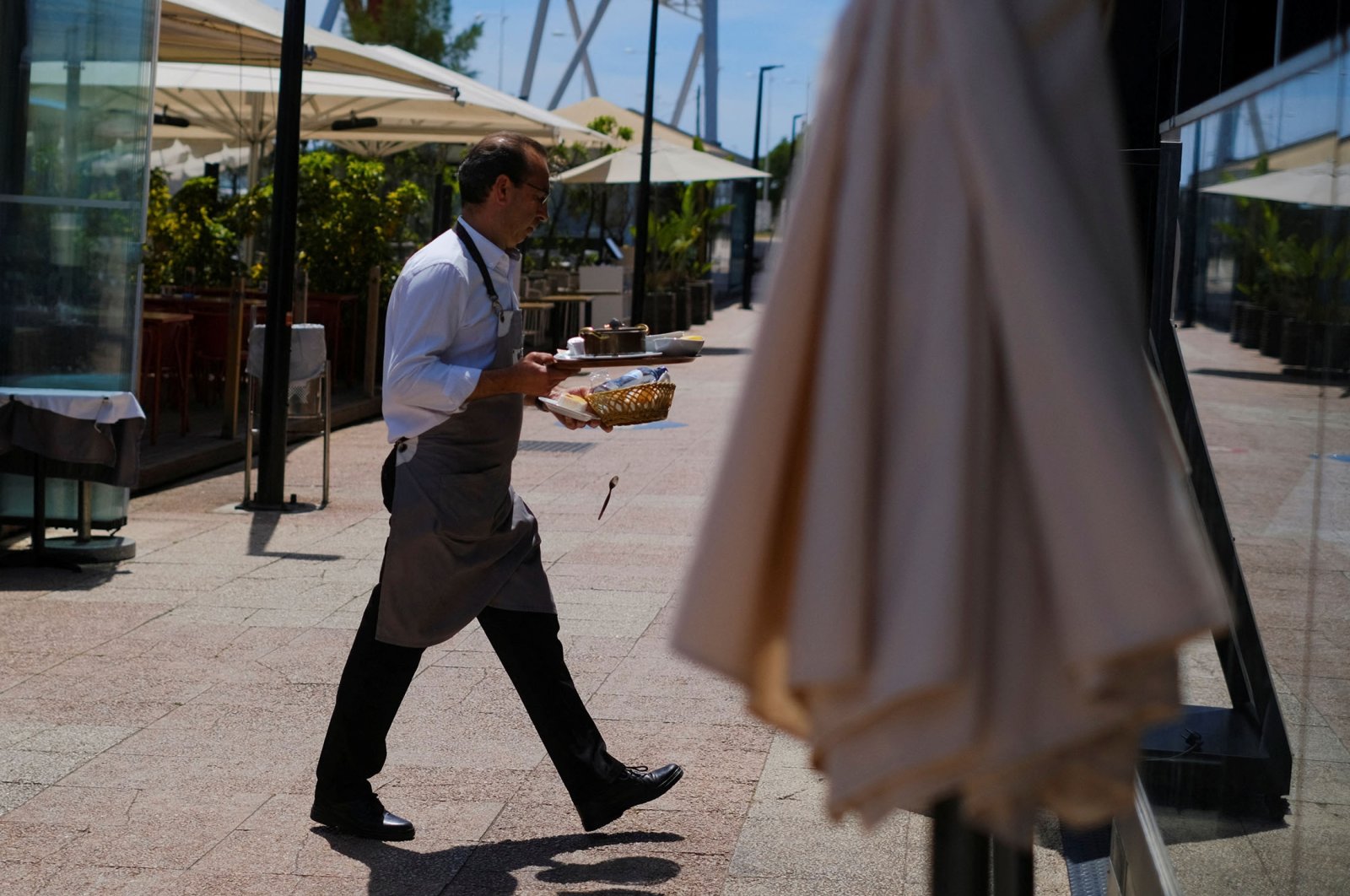 A waiter clears the table in a restaurant in Lisbon, Portugal, June 6, 2022. (Reuters Photo)
