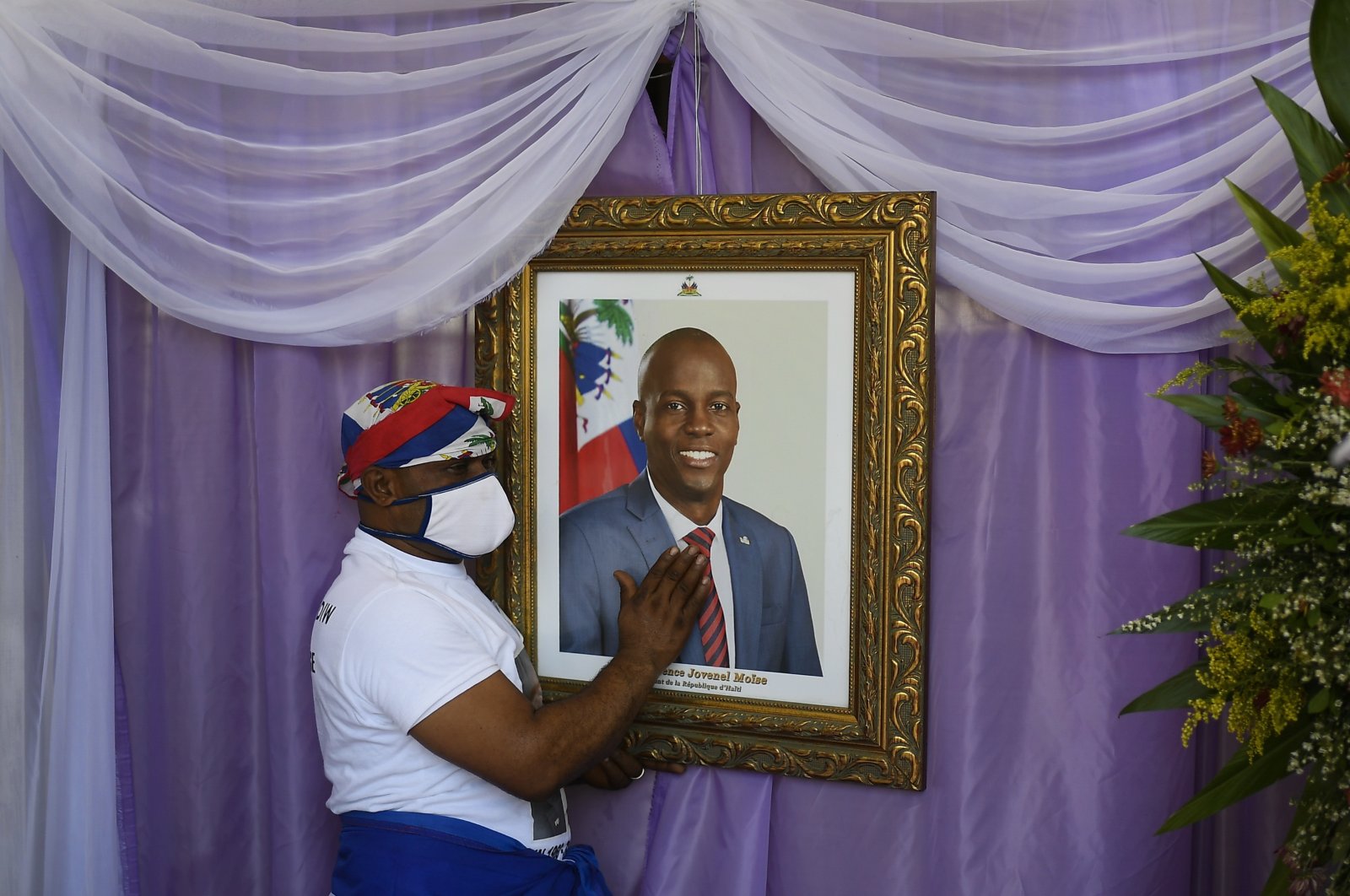 A man touches the portrait of the late Haitian President Jovenel Moise, in Cap-Haitien, Haiti, July 22, 2021. (AP PHOTO)