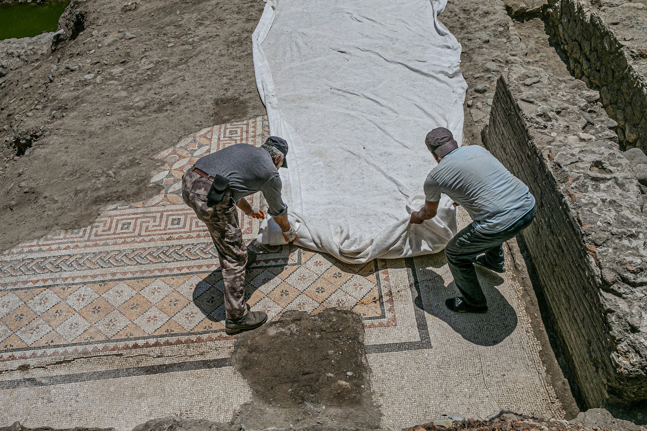 Workers work on the mosaic on the floor of a recently discovered Roman villa in the Defne district of Hatay, southern Turkey, July 4, 2022. (AA Photo)