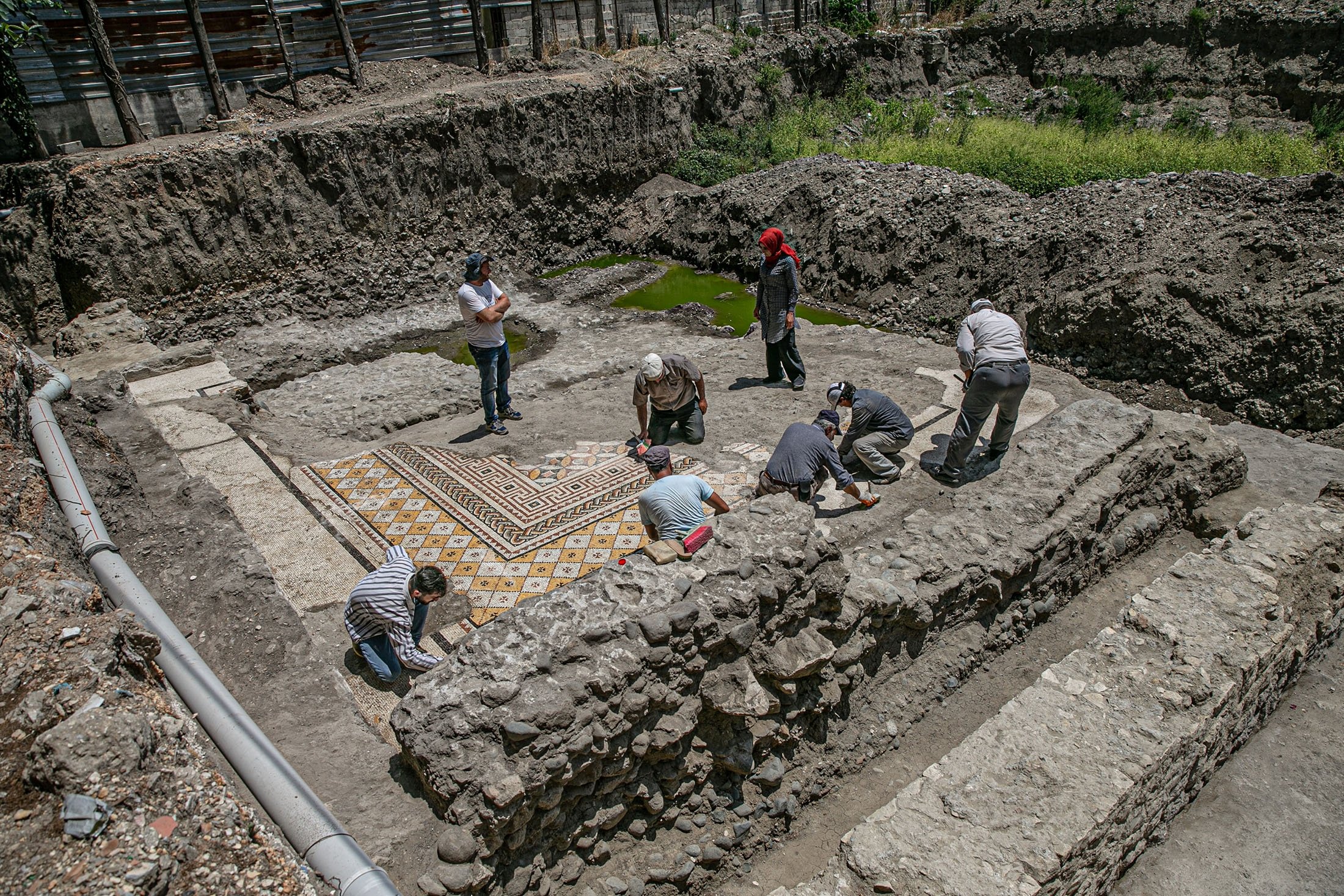 Workers clean the mosaic on the floor of a recently discovered Roman villa in the Defne district of Hatay, southern Turkey, July 4, 2022. (AA Photo)