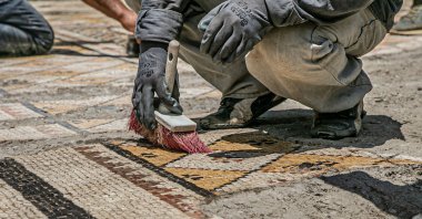 Workers clean the mosaic on the floor of a recently discovered Roman villa in the Defne district of Hatay, southern Turkey, July 4, 2022. (AA Photo)