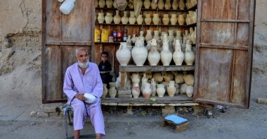 A vendor selling utensils sits beside his kiosk in Zhari district, Kandahar, Afghanistan, June 22, 2022. (AFP Photo)