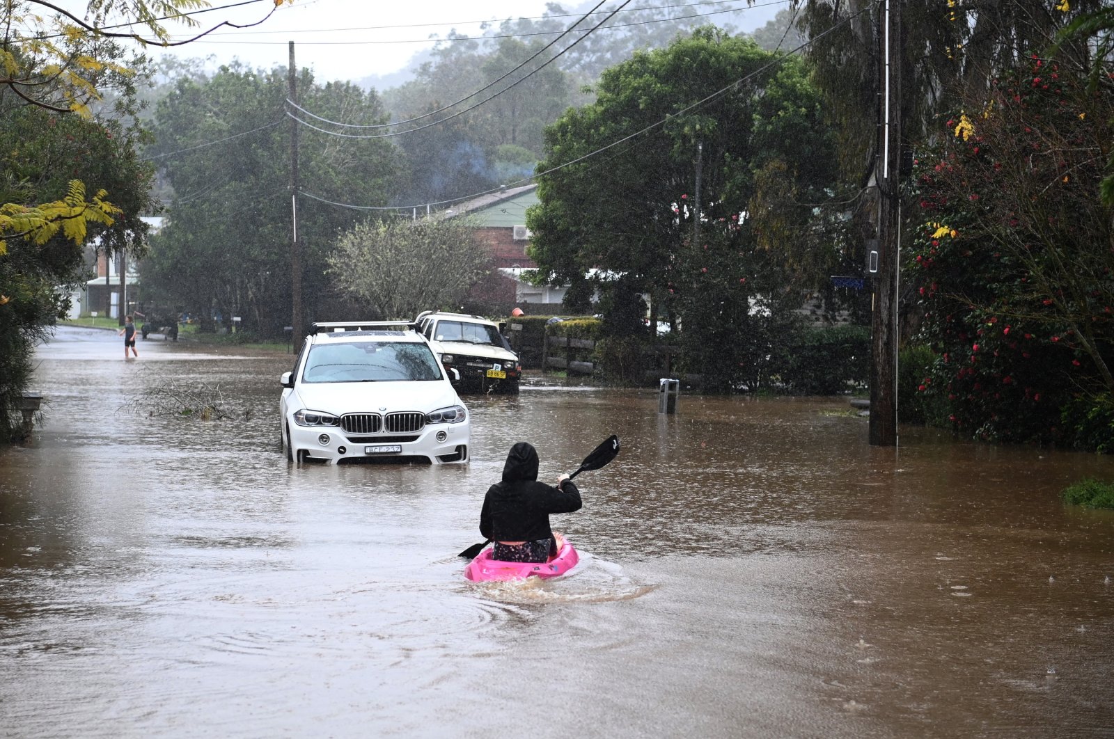 Children are seen on kayaks in floodwaters which have inundated the town of Yarramalong on the Central Coast, north of Sydney, Australia, July 5, 2022. (EPA Photo)