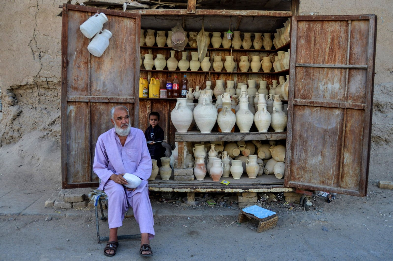 A vendor selling utensils sits beside his kiosk in Zhari district, Kandahar, Afghanistan, June 22, 2022. (AFP Photo)