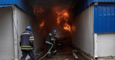 Firefighters spray water onto a fire at the market after shelling in Sloviansk, Donetsk region, Ukraine, July 5, 2022. (Reuters Photo)