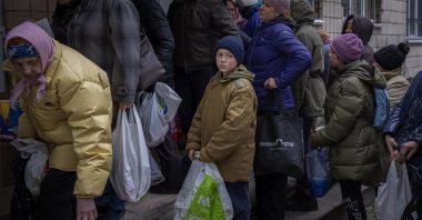 Sergei, 11, waits for his turn to receive donated food during an aid humanitarian distribution in Bucha, in the outskirts of Kyiv, Ukraine, April 19, 2022. (AP Photo)